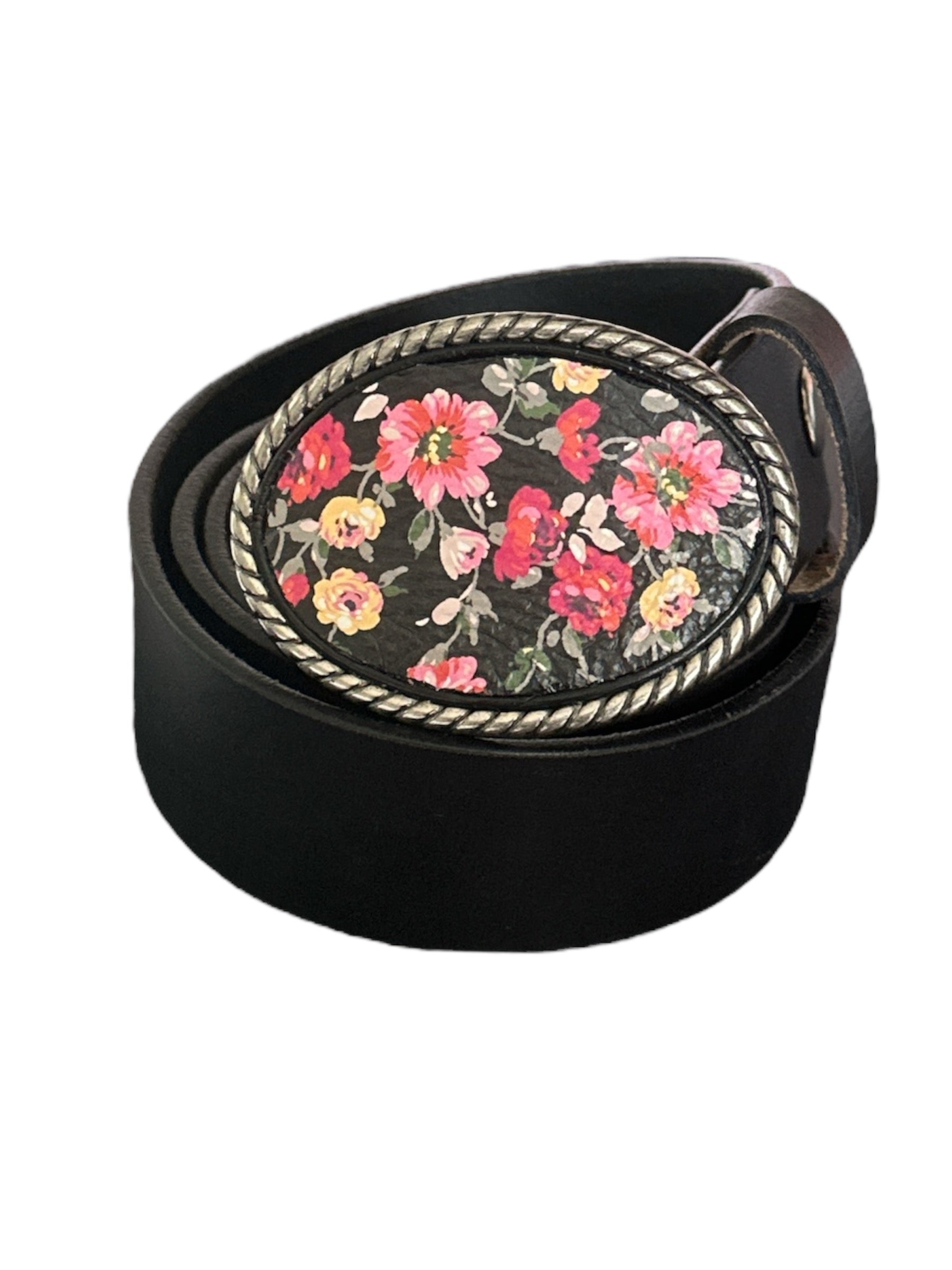 A black floral leather belt buckle with vibrant red, pink, and yellow roses on a white background, oval rope design border, and a silver-tone snap.