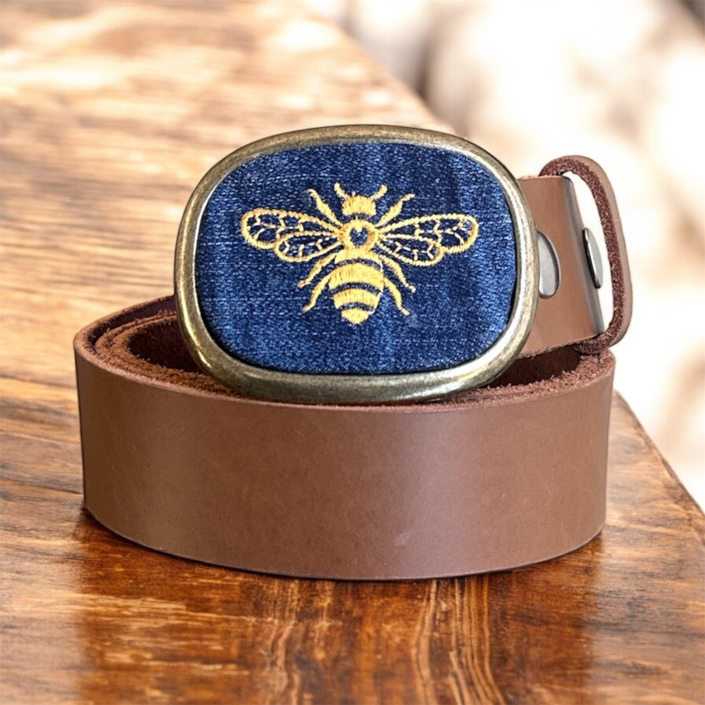 bumble bee embroidered on jean belt buckle with brown belt. 