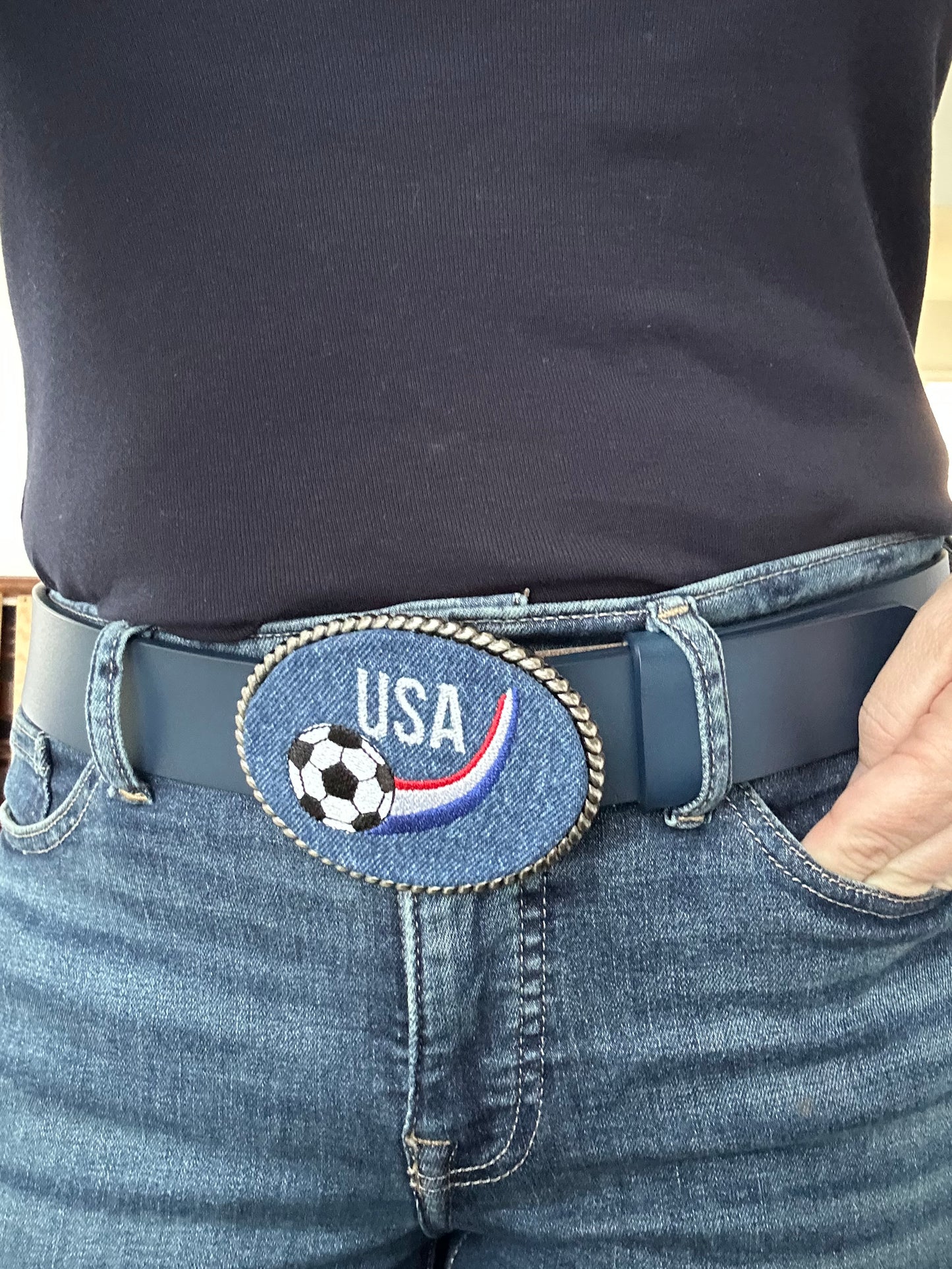 Person wearing a blue interchangeable  belt with a 'USA Soccer' buckle.