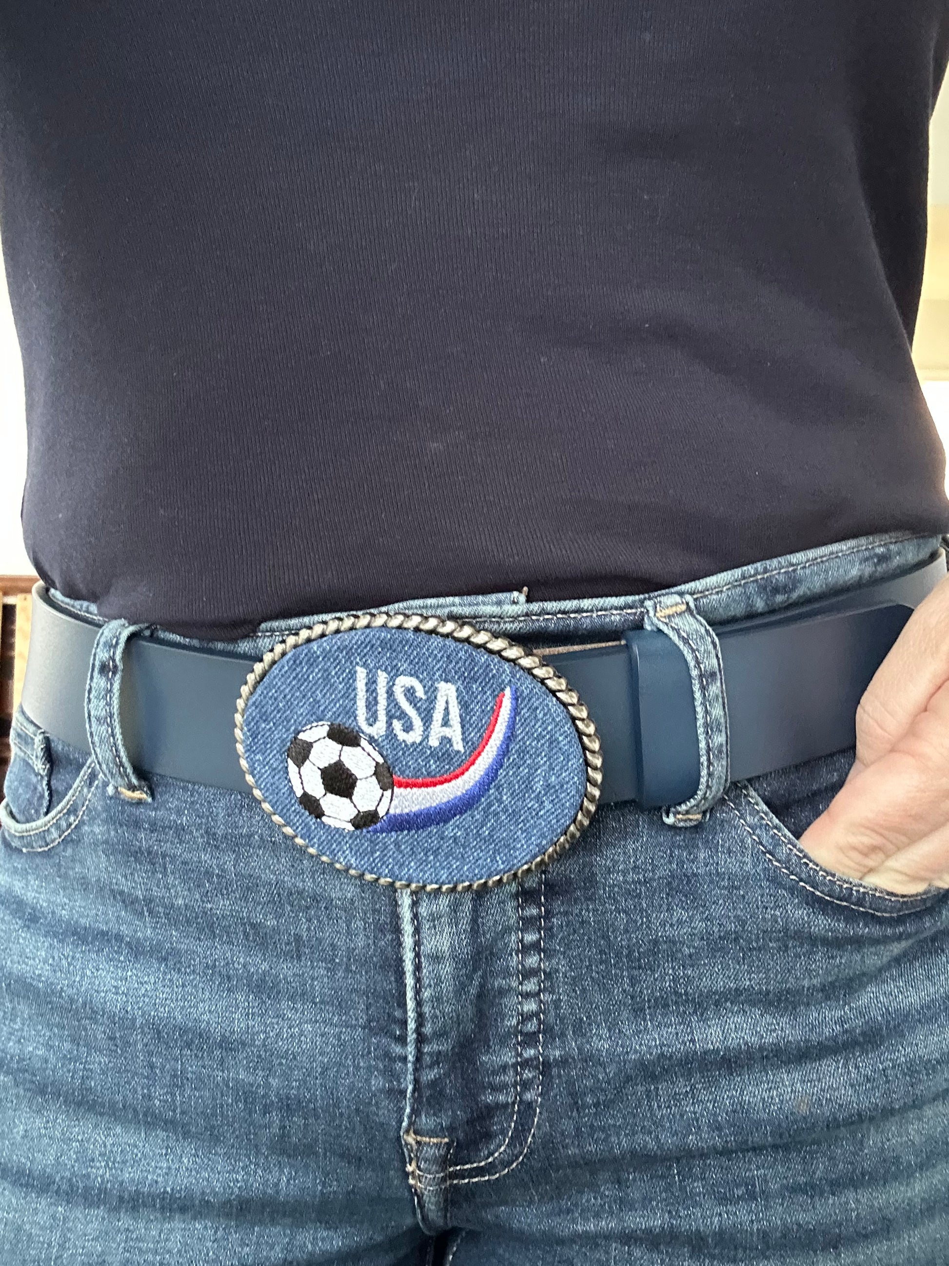 Person wearing a blue interchangeable  belt with a 'USA Soccer' buckle.