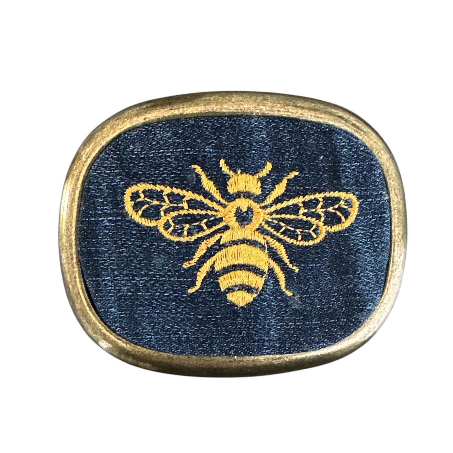 a gold bumblebee embroidered on denim jean set in an antique brass belt buckle