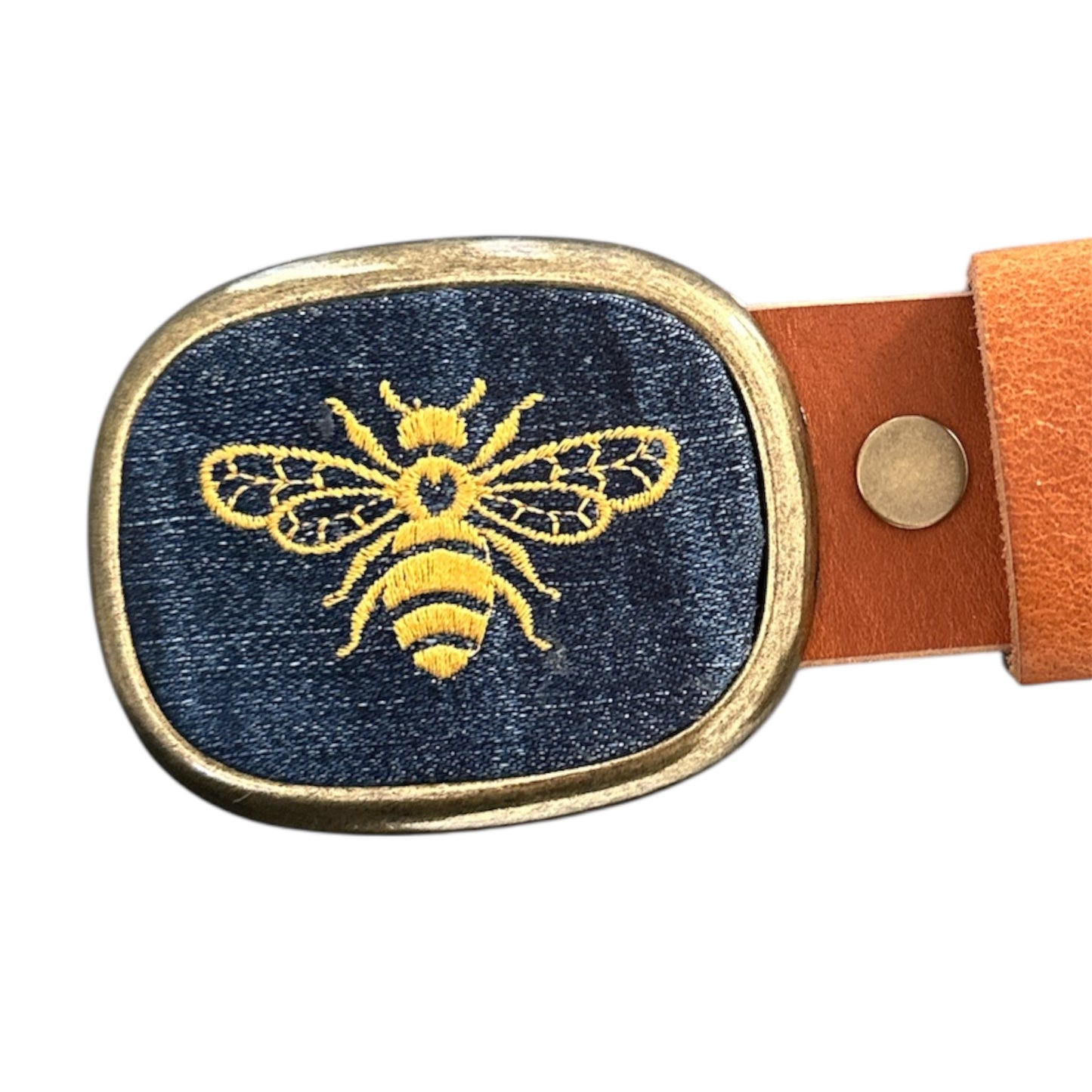 A Bumble bee embroidered on denim in a belt buckle on white background 